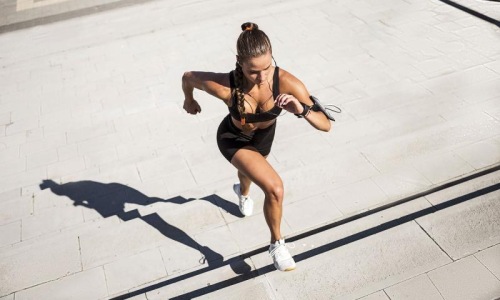 woman exercises running outside up stairs